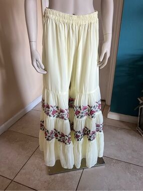 La pink Boho Pale Yellow Wide-Leg Tiered Pants with Floral Embroidery